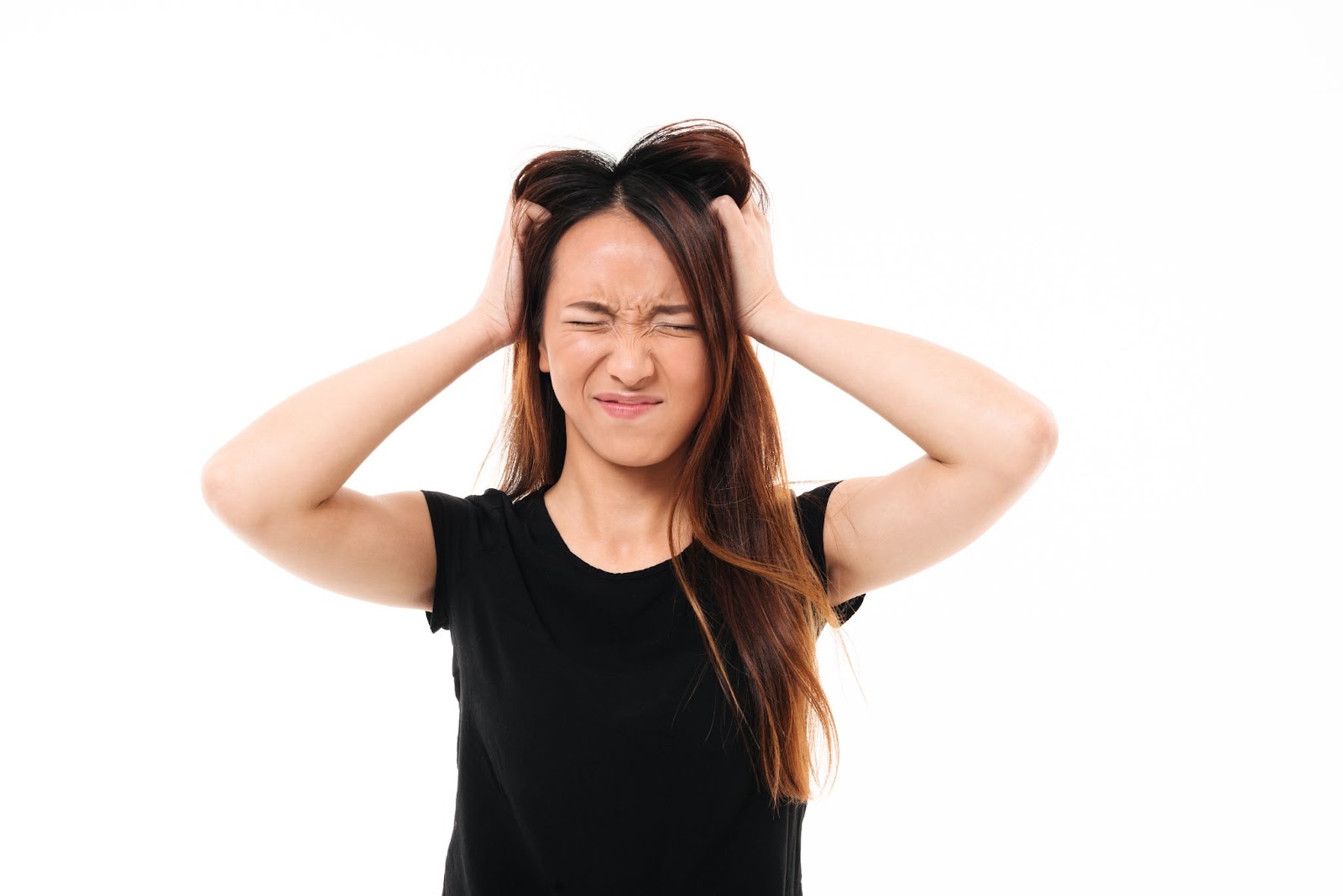 Stressed woman holding hands on head.